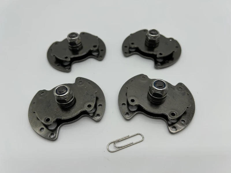 Batch of custom SK7 stamped torque hinges with black nickel plating after assembly