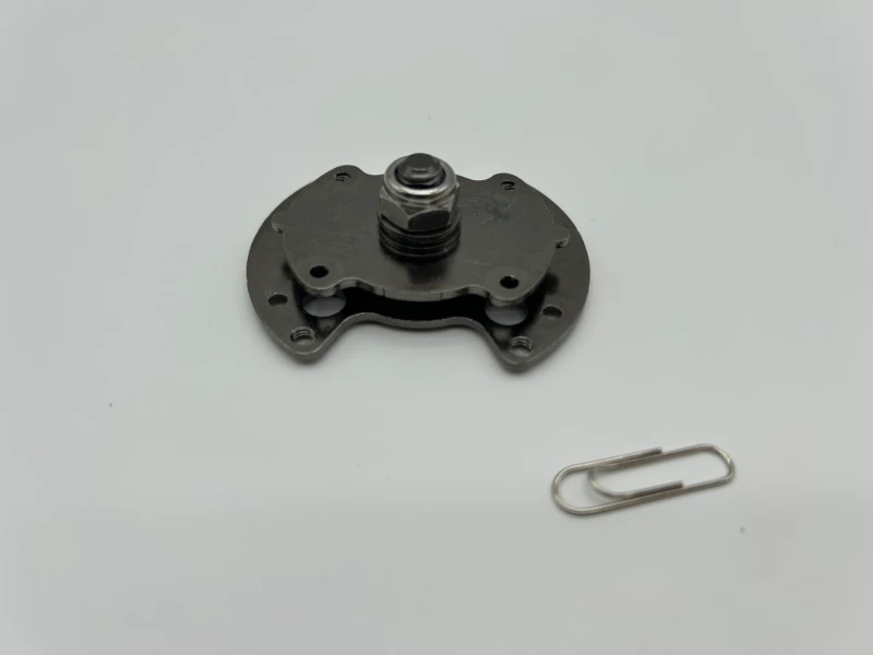 Custom SK7 stamped torque hinge assembly with black nickel plating and central pivot shaft