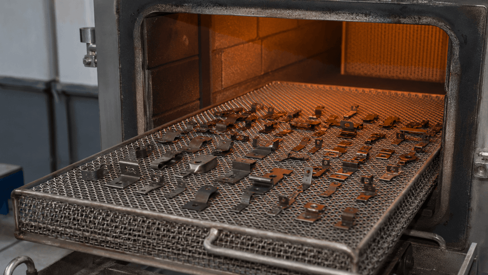 65Mn stamped steel parts undergoing heat treatment in an industrial furnace