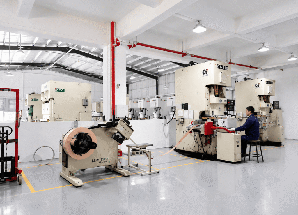 High precision stamping workshop with servo press machines and operator working in a modern clean metal manufacturing factory