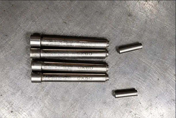 Multiple broken punch pins showing stamping tool failure after repeated production cycles