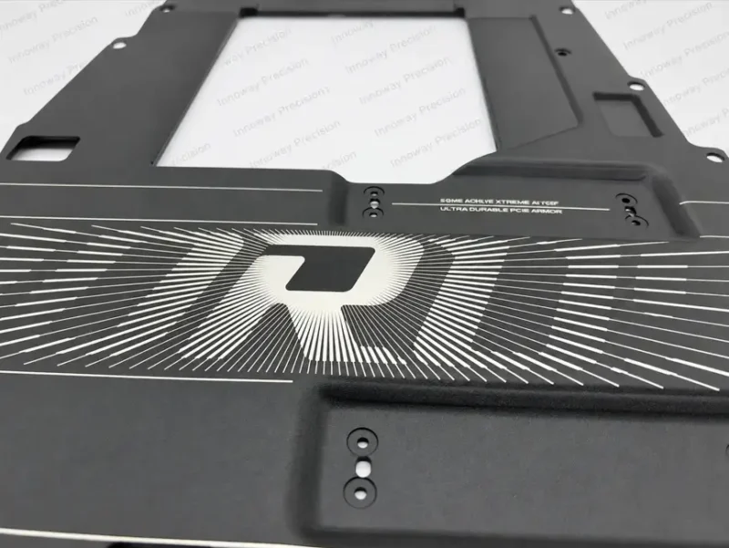 Precision Laser Engraving on Black Powder-Coated Aluminum Close-up of laser-engraved metallic graphics on a black powder-coated aluminum motherboard panel.