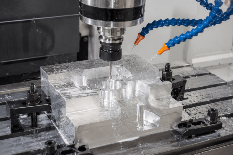 CNC milling machine machining an aluminum workpiece with precision cutting tools and coolant during a manufacturing process